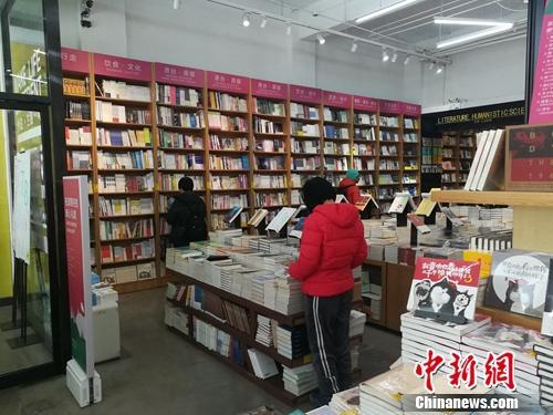 资料图：北京言几又书店(中关村店)内，读者正在翻看摆放的书籍。上官云 摄