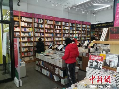 资料图:北京言几又书店(中关村店)内,读者正在翻看摆放的书籍。上官云 摄